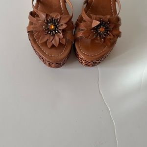 This shoes is made in Brazil with brown leather and some ornament that makes
